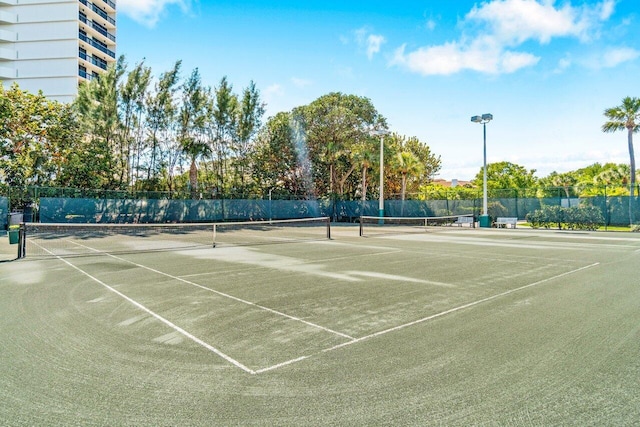 view of tennis court featuring fence