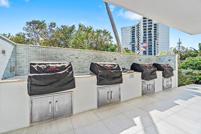 view of patio featuring an outdoor kitchen and a grill