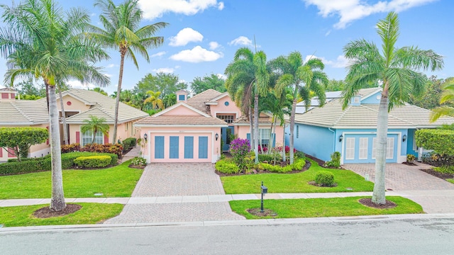 view of front of property with a front lawn, decorative driveway, and french doors