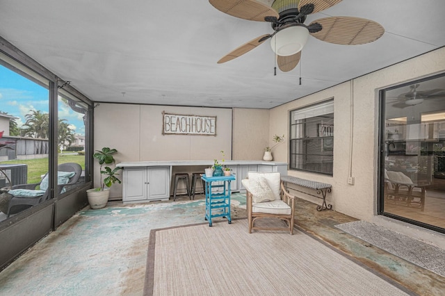 sunroom / solarium featuring a ceiling fan