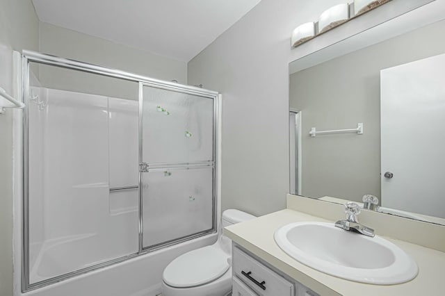 full bathroom featuring bath / shower combo with glass door, vanity, and toilet