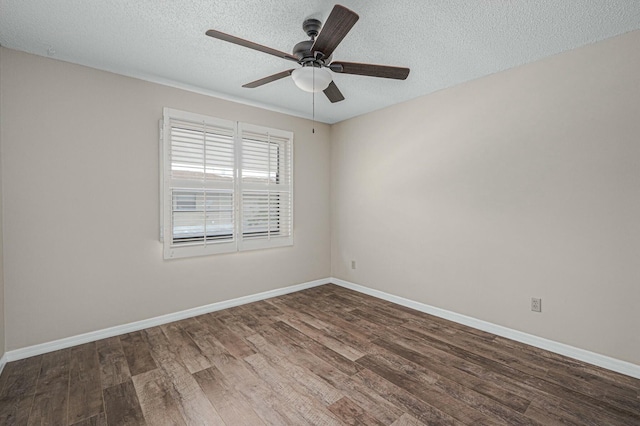 empty room featuring a ceiling fan, a textured ceiling, baseboards, and dark wood-style flooring