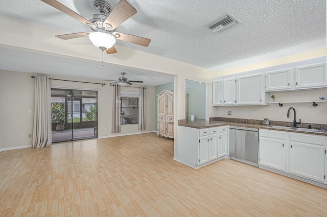 kitchen with visible vents, dishwasher, light wood-style floors, open shelves, and a sink