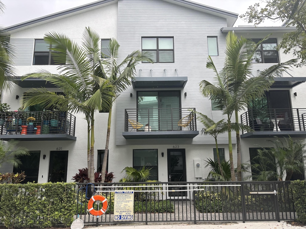 view of front facade featuring fence and stucco siding