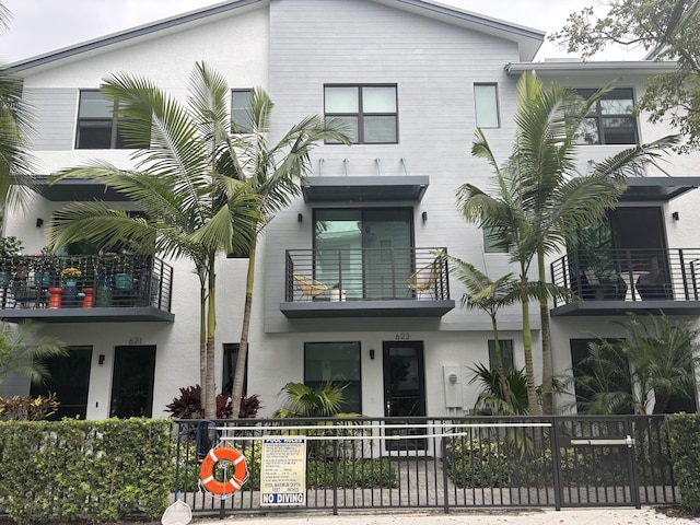 view of front facade featuring fence and stucco siding