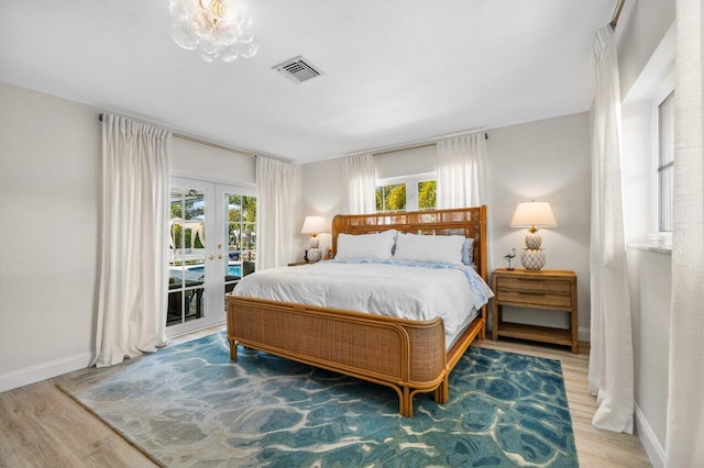 bedroom with wood finished floors, visible vents, baseboards, access to exterior, and french doors