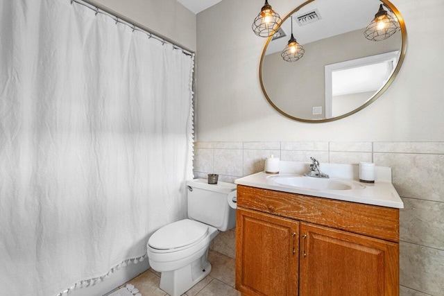 full bathroom featuring tile patterned flooring, visible vents, toilet, vanity, and tile walls