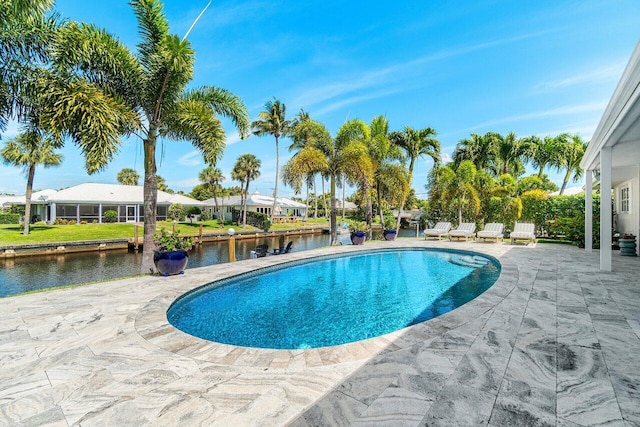 view of pool with a patio area, a water view, and a residential view