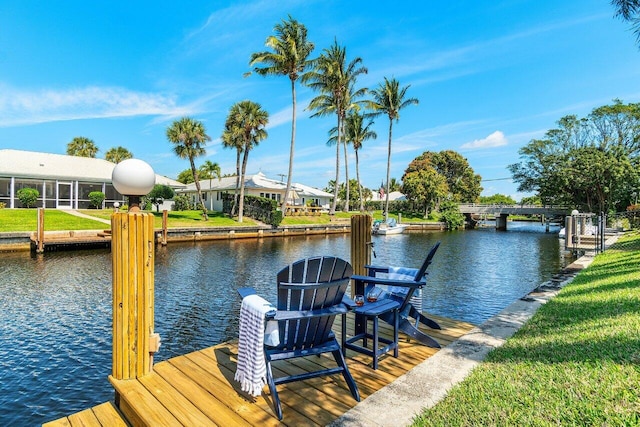 view of dock featuring a water view and a lawn