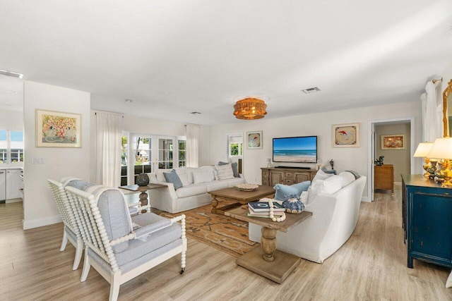 living area with visible vents, baseboards, and light wood-style floors