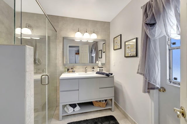 full bath featuring vanity, baseboards, tile patterned flooring, and a stall shower