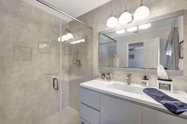 bathroom with ceiling fan, visible vents, a shower stall, and vanity