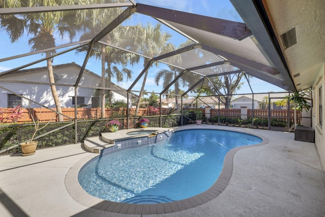view of swimming pool with a patio, a fenced backyard, glass enclosure, and a pool with connected hot tub
