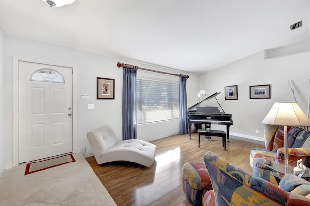living room with baseboards, wood finished floors, and visible vents