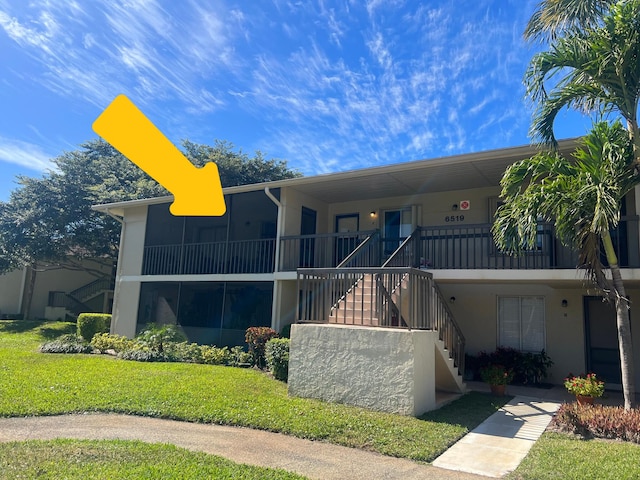 townhome / multi-family property featuring stairway, a front yard, and stucco siding