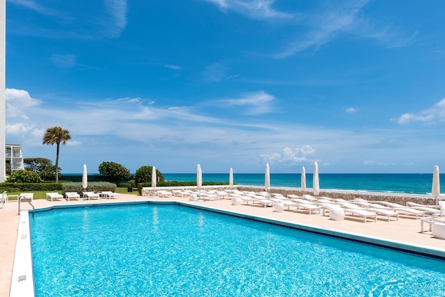 pool featuring a patio and a water view