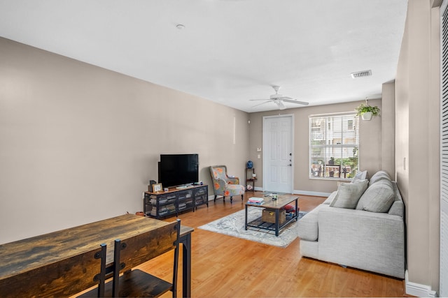 living room with baseboards, ceiling fan, visible vents, and wood finished floors