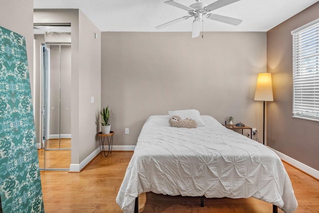 bedroom featuring light wood-type flooring, baseboards, and a ceiling fan