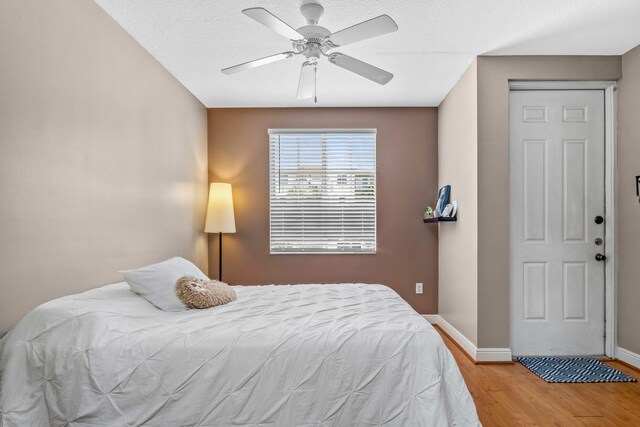 bedroom featuring ceiling fan, baseboards, and wood finished floors