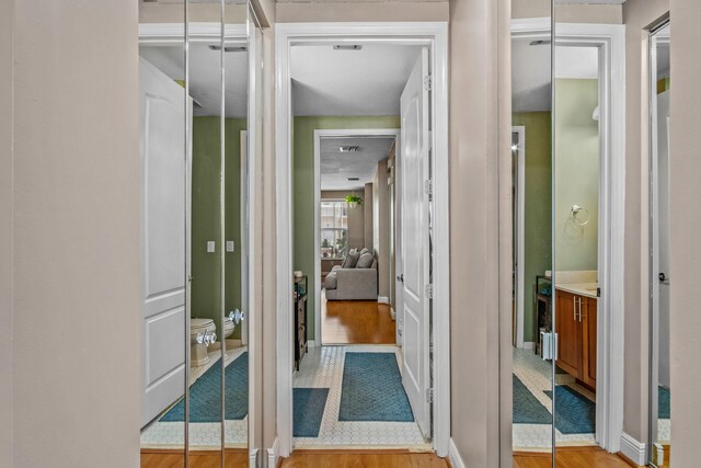 interior space with toilet, baseboards, wood finished floors, and vanity