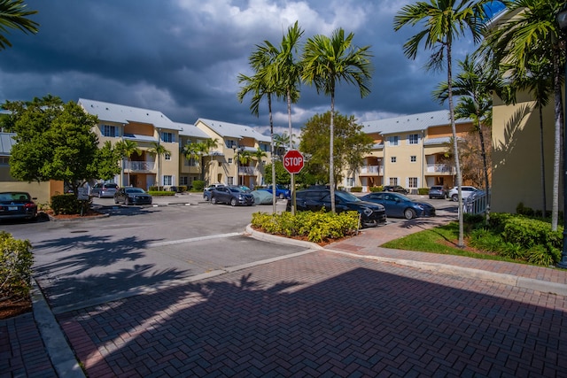 view of road with traffic signs, a residential view, and curbs