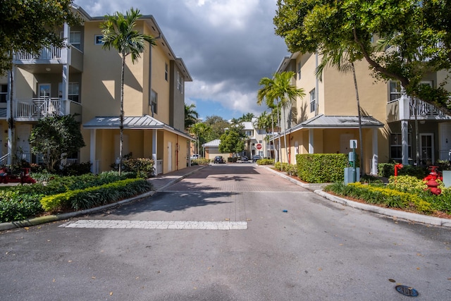 view of street with traffic signs, a residential view, and curbs