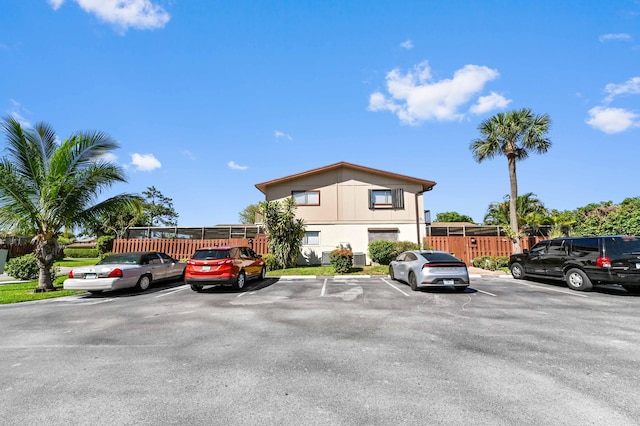 view of front of house featuring fence and uncovered parking