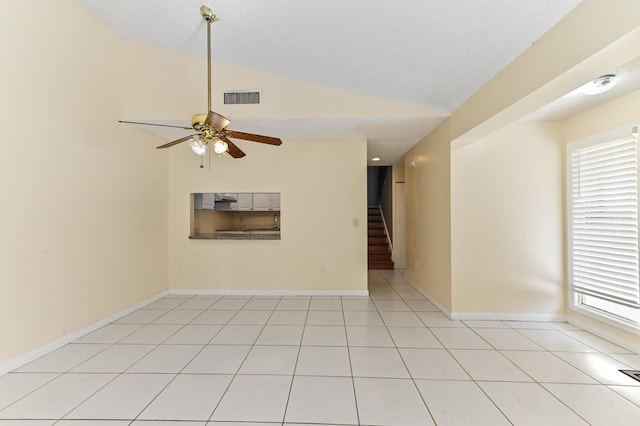 unfurnished room featuring visible vents, stairway, vaulted ceiling, light tile patterned floors, and a ceiling fan