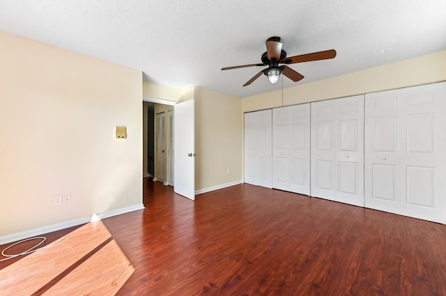 unfurnished bedroom featuring baseboards, wood finished floors, a closet, a textured ceiling, and a ceiling fan