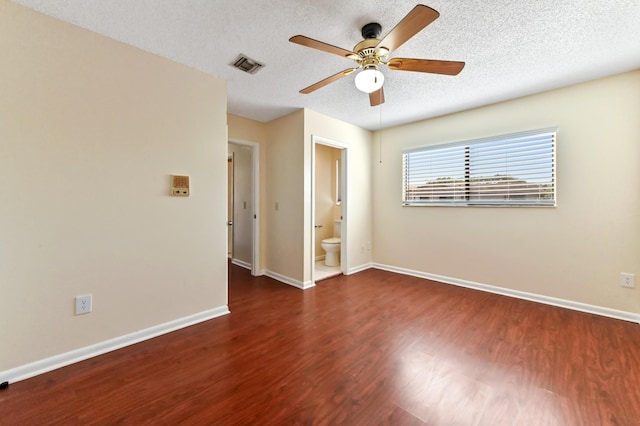 unfurnished room featuring a ceiling fan, baseboards, wood finished floors, visible vents, and a textured ceiling