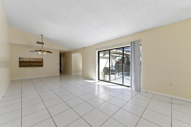 unfurnished room featuring a textured ceiling, tile patterned flooring, baseboards, ceiling fan, and vaulted ceiling