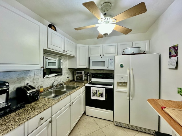 kitchen with a sink, white appliances, white cabinetry, and light tile patterned floors