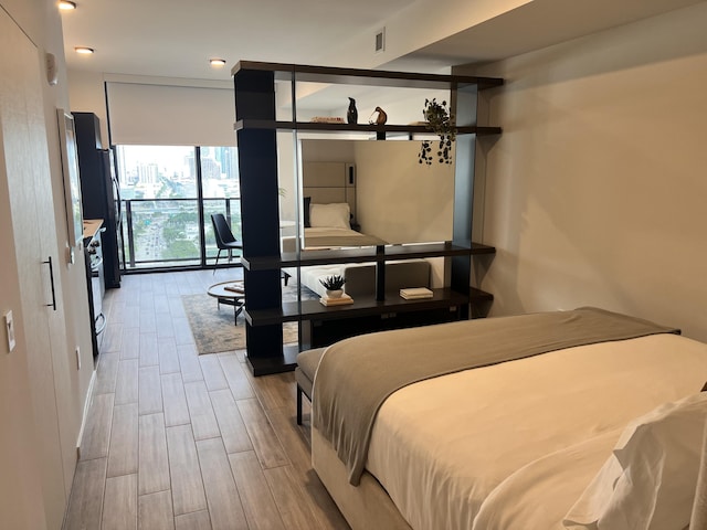 bedroom featuring wood finish floors and visible vents