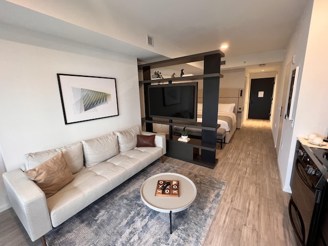 living area featuring light wood-type flooring, visible vents, and baseboards