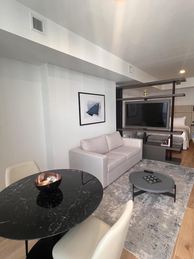 living area with visible vents and wood finished floors