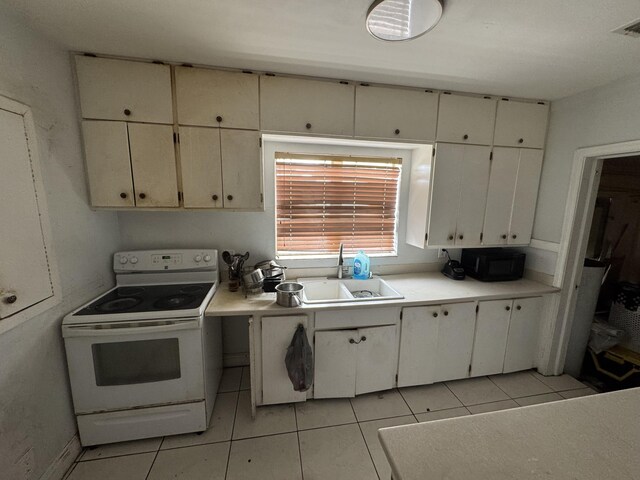 kitchen featuring light tile patterned floors, light countertops, electric range, a sink, and black microwave