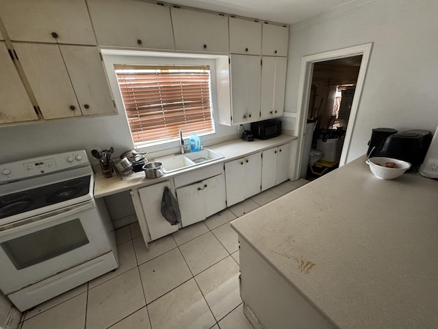 kitchen with white range with electric stovetop, light countertops, a sink, and light tile patterned flooring