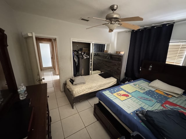 bedroom featuring a ceiling fan, a closet, visible vents, and light tile patterned floors