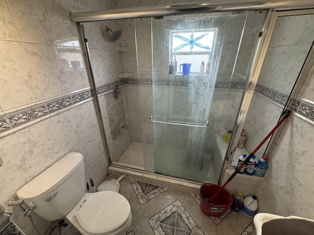 full bath featuring a stall shower, tile walls, and toilet