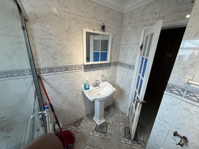 bathroom featuring ornamental molding, a shower with shower door, and tile walls