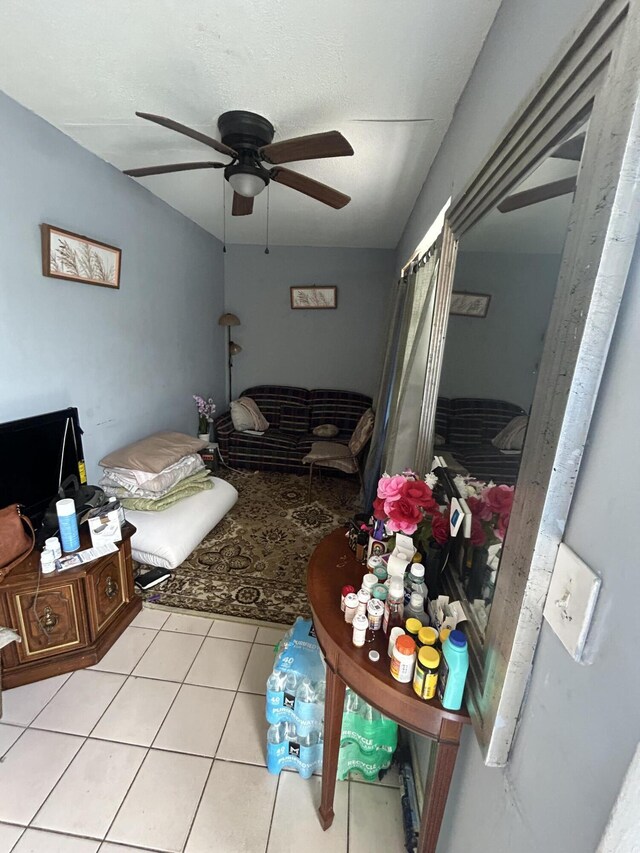 living room with a ceiling fan and tile patterned floors