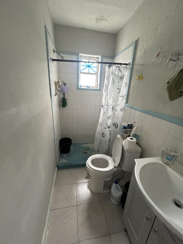 full bathroom featuring toilet, tile patterned flooring, a textured ceiling, a shower stall, and tile walls