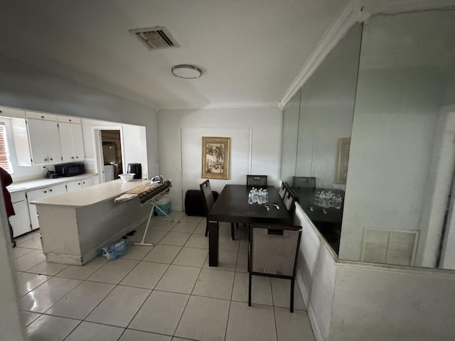 kitchen featuring black microwave, light tile patterned flooring, visible vents, and white cabinets