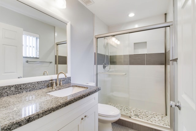 full bathroom with visible vents, a stall shower, vanity, and toilet