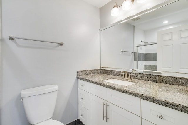 bathroom with toilet, a stall shower, vanity, and visible vents