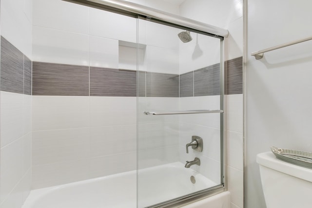 full bathroom featuring bath / shower combo with glass door and toilet