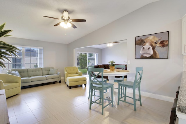 dining room with lofted ceiling, baseboards, and a ceiling fan