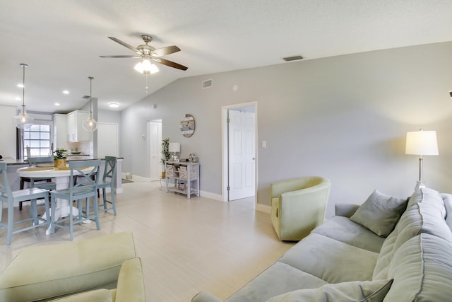 living area with vaulted ceiling, baseboards, visible vents, and a ceiling fan