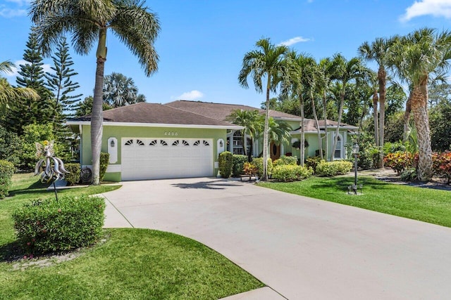 ranch-style house with a garage, stucco siding, concrete driveway, and a front yard