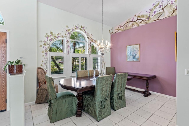 dining space featuring a high ceiling, a notable chandelier, light tile patterned flooring, and baseboards